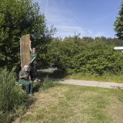 Neu aufgebaute Eichenstele mit Sitzbank beim WildparkHaus in Neuhaus, rechts daneben ein neuer Wegweiser.